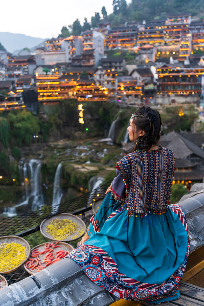 Mujer viendo de lejos la ciudad deLijiang China
